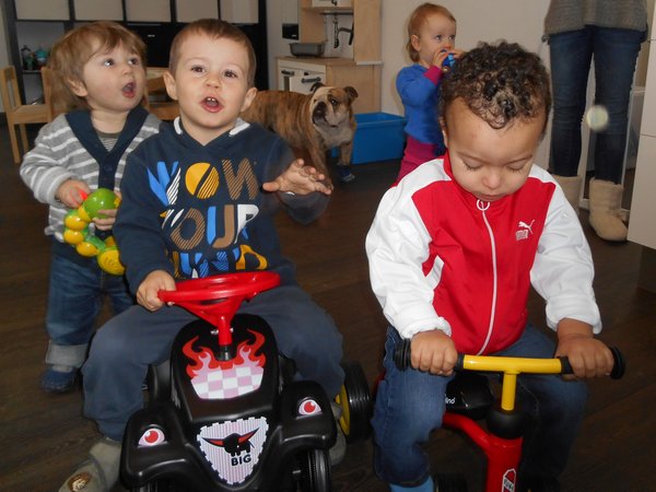 Kinder mit Bobby-Car und Dreirad